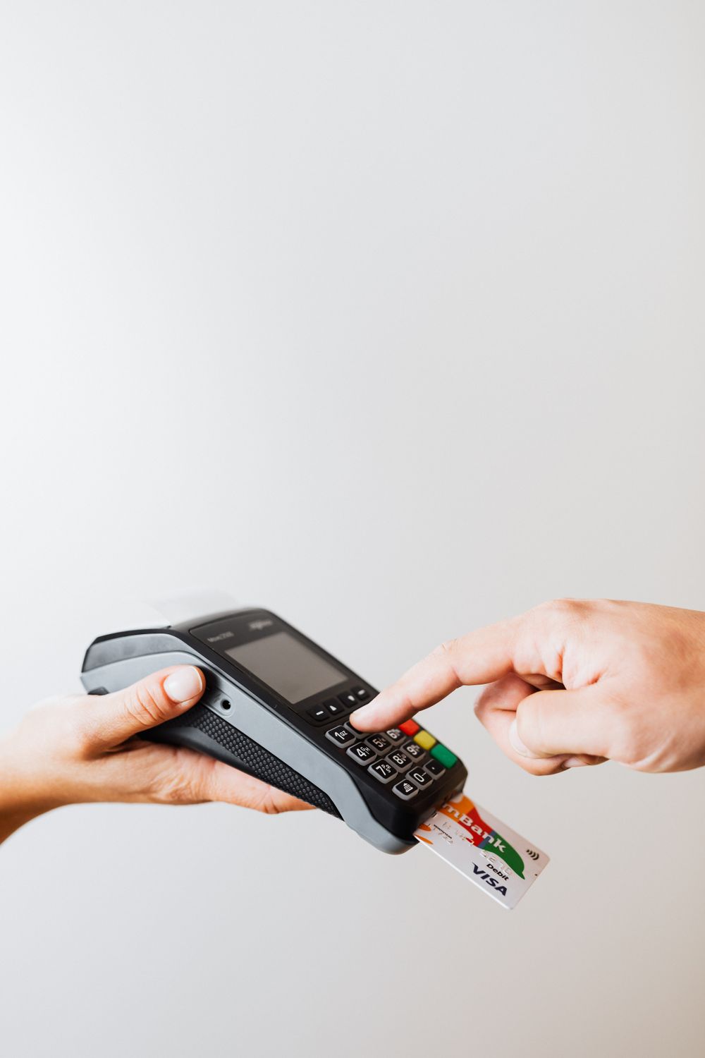 Close-up of card payment using POS terminal, emphasizing cashless transaction.
