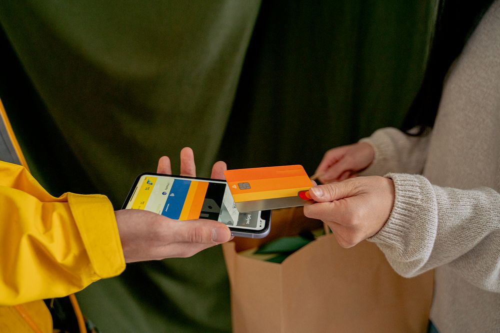 A close-up of a contactless payment using a credit card and smartphone, highlighting modern technology.