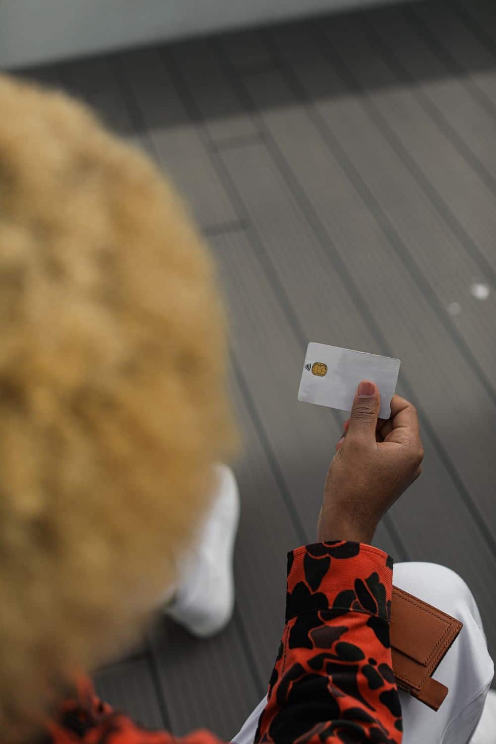 Close-up shot of a person holding a bank card, captured from a unique perspective.