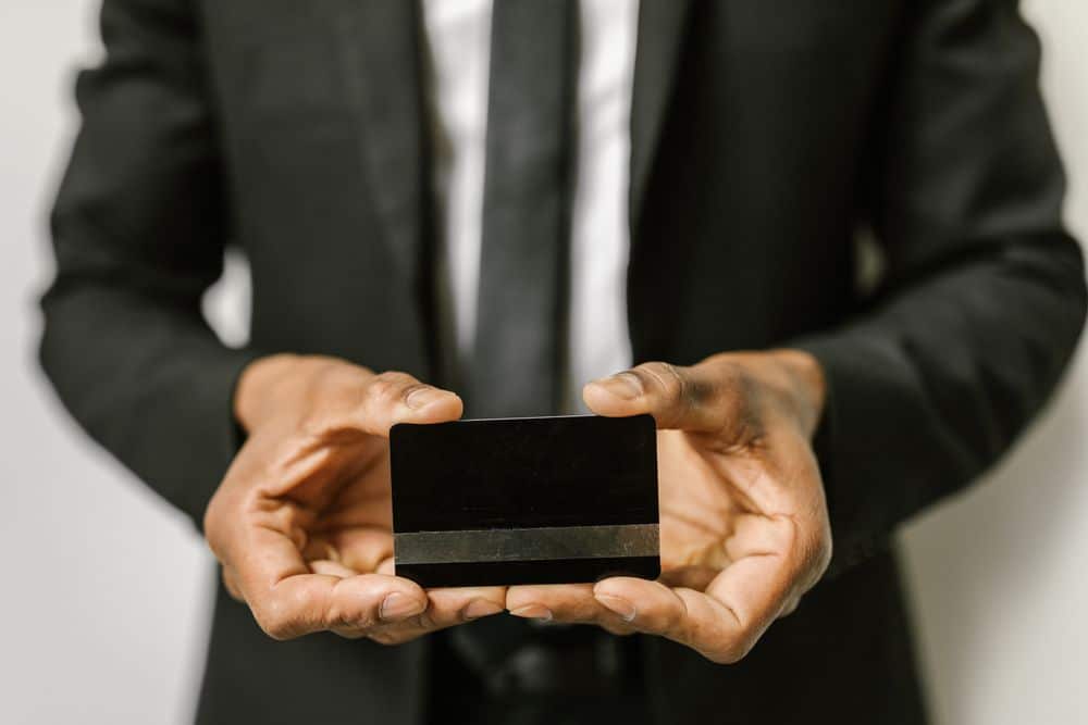 Close-up of a businessman holding a blank credit card with both hands, emphasizing finance.
