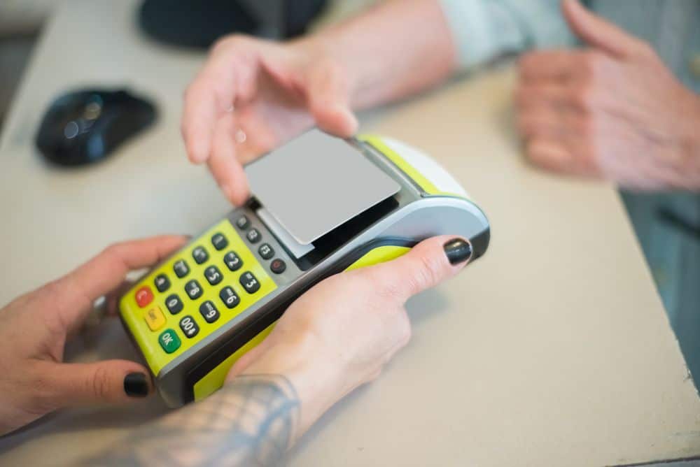 Hands engaging in a secure card transaction with a payment terminal, capturing the essence of modern business transactions.