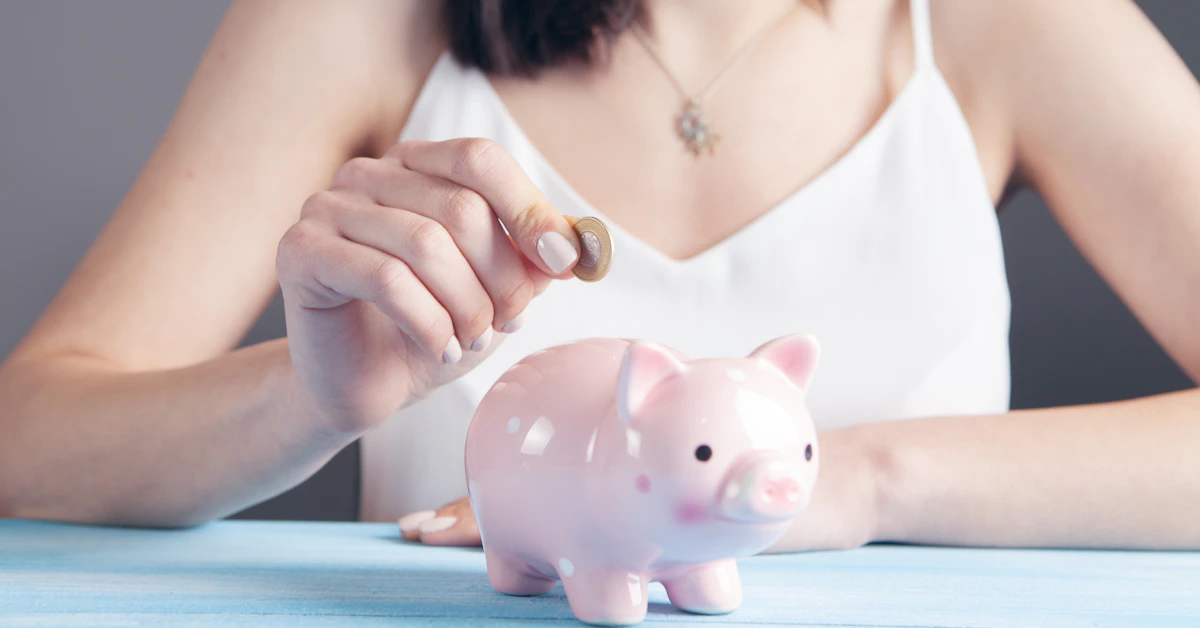 woman in white tank top holding pink pig figurine