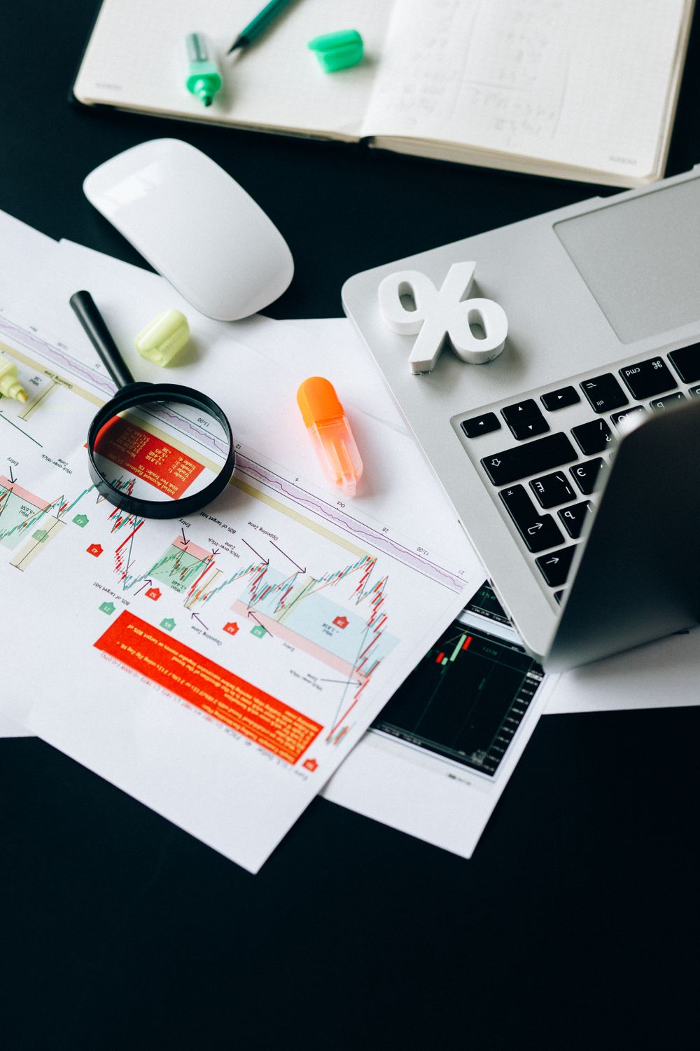 A top view of a workspace featuring financial documents, a laptop, and office supplies emphasizing data analysis.
