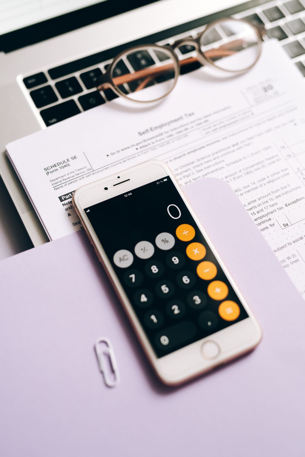 Close-up of a smartphone calculator on tax documents, representing business accounting.