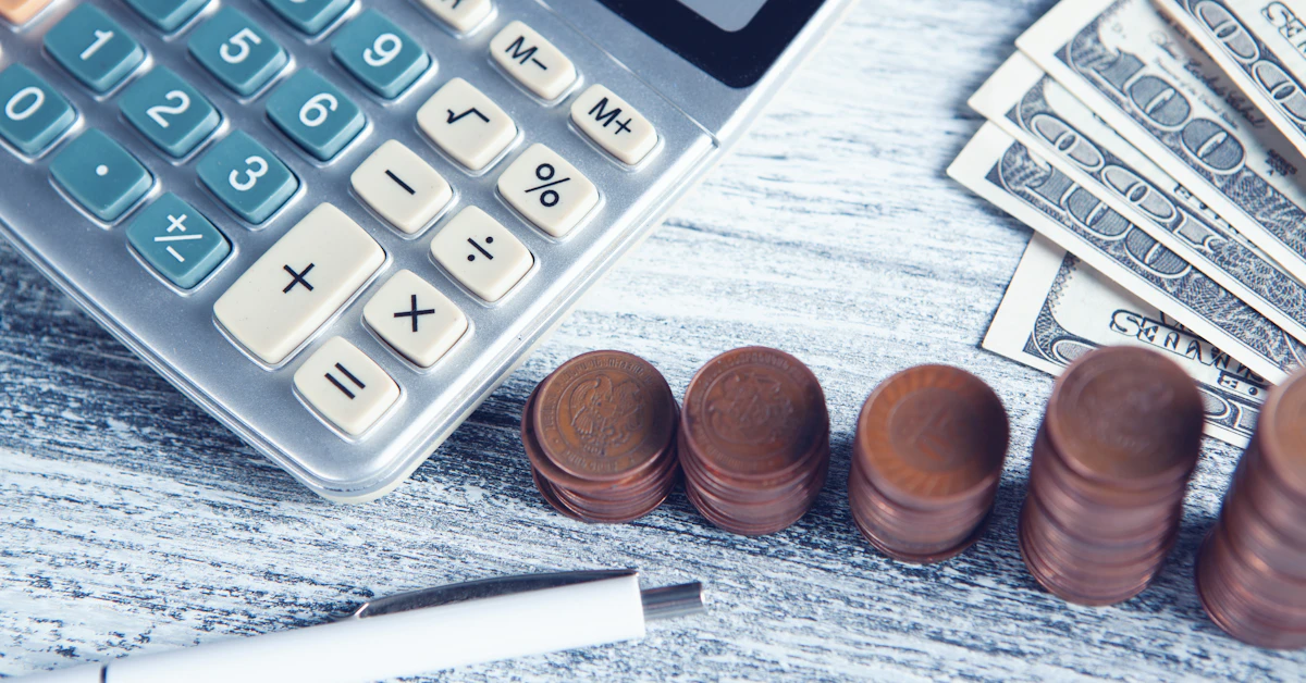 a calculator, pen, and money on a table