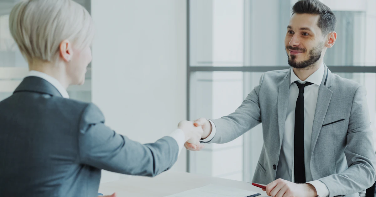 Two professionals shaking hands across a table
