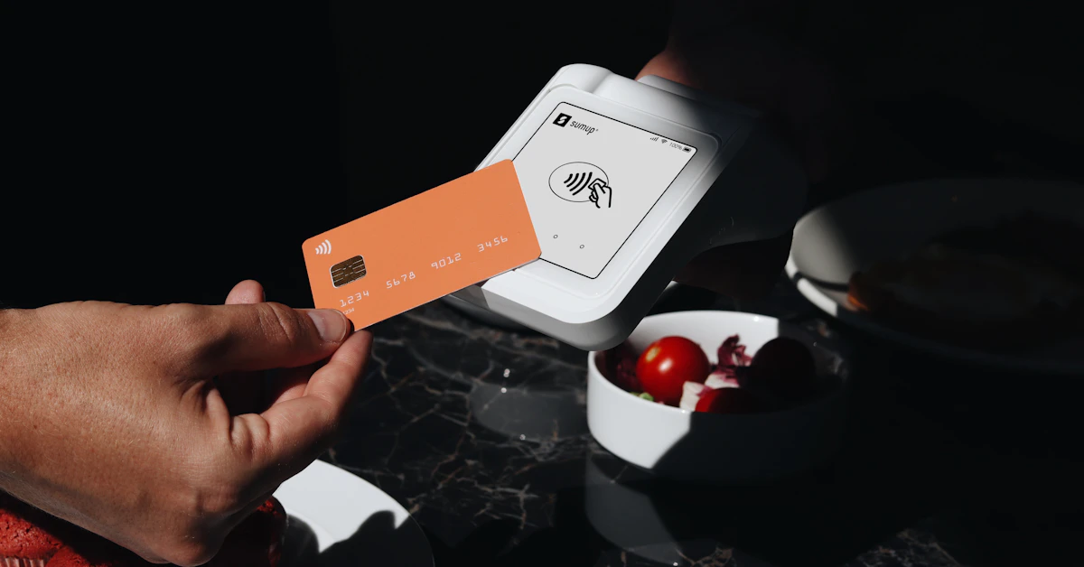 A person holding a credit card over a plate of food